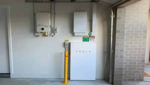 Tesla Powerwall with SolarEdge installation in Forde ACT by Stag Electrical Solar and Refrigeration team members installing solar panels on a roof.