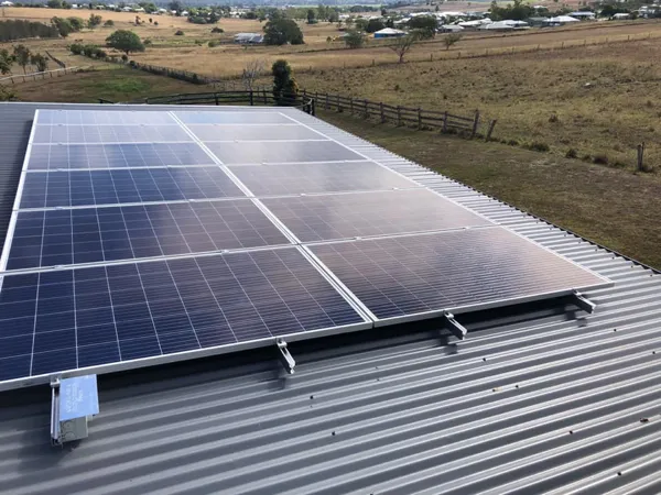 Nice shot of some solar panels on a roof in a rural setting.